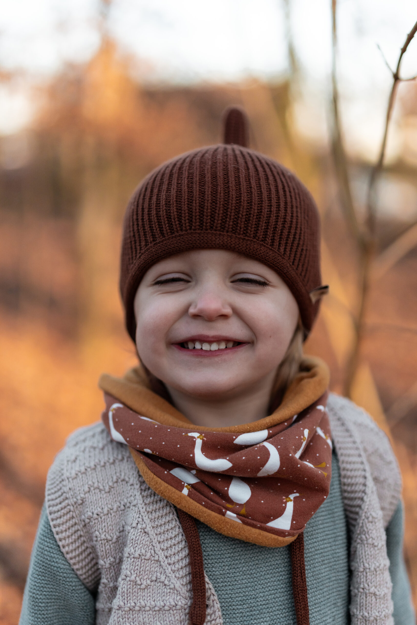 Kindergartenkind mit brauner Mütze im Garten